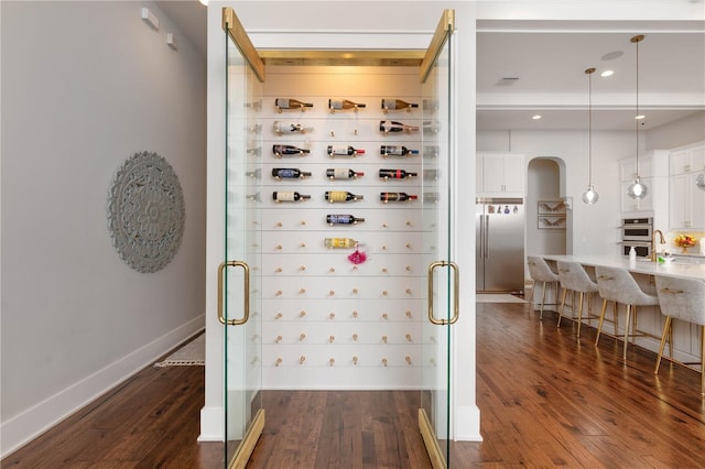 wine area featuring dark wood finished floors, visible vents, and baseboards