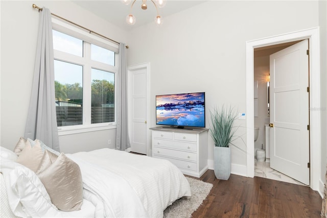 bedroom featuring a notable chandelier, baseboards, and wood finished floors