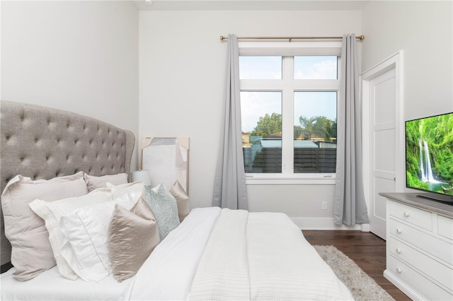 bedroom featuring dark wood-style floors and baseboards