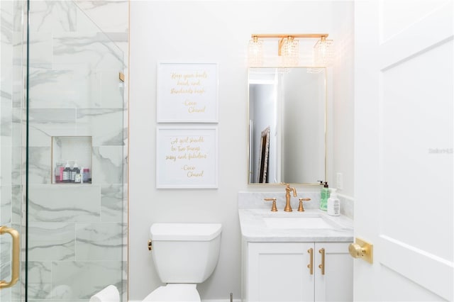 bathroom featuring toilet, a stall shower, and vanity