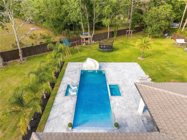 view of pool with a fenced backyard, a trampoline, a lawn, and a patio