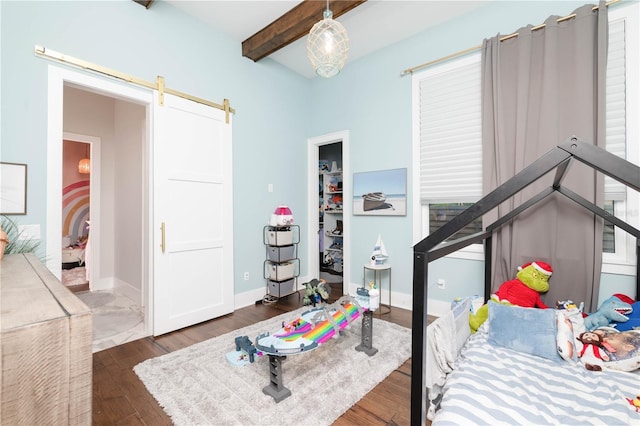 bedroom featuring a barn door, baseboards, beamed ceiling, and wood finished floors