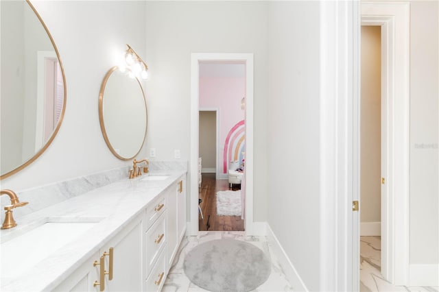 full bath with marble finish floor, a sink, and baseboards