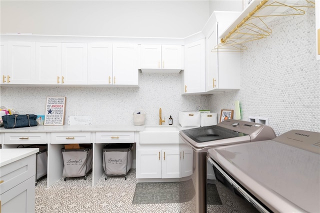 laundry area with independent washer and dryer, a sink, and cabinet space