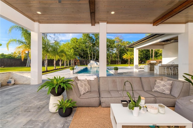 view of patio / terrace with an outdoor kitchen, a fenced backyard, an outdoor hangout area, and a fenced in pool