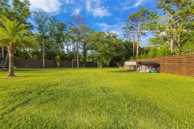 view of yard with an outdoor structure and a fenced backyard