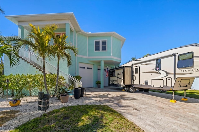 15904 Redington Dr, Redington Beach, FL 33708 - view of front of house with an attached garage, stairway, and decorative driveway