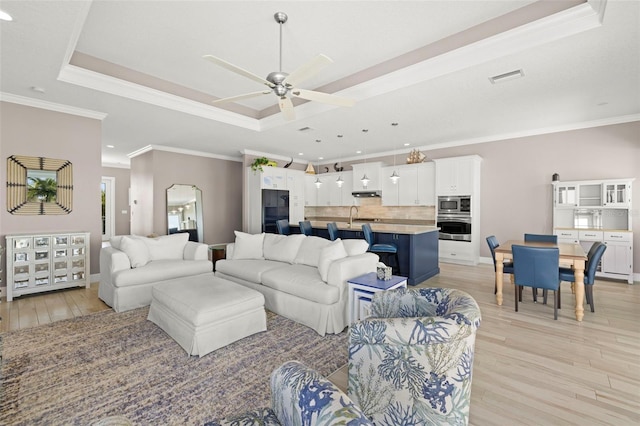 15904 Redington Dr, Redington Beach, FL 33708 - living room with light wood-type flooring, a tray ceiling, visible vents, and crown molding