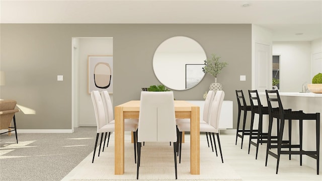 dining area featuring carpet and baseboards