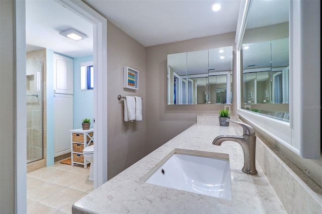 bathroom with vanity, tile patterned floors, toilet, and a stall shower