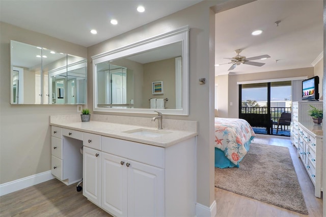 bathroom with ceiling fan, baseboards, recessed lighting, wood finished floors, and vanity