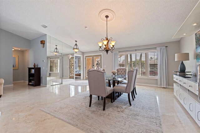 dining space with marble finish floor, a notable chandelier, visible vents, a textured ceiling, and baseboards