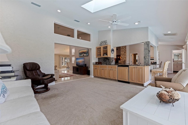 living room with light carpet, a skylight, visible vents, and recessed lighting