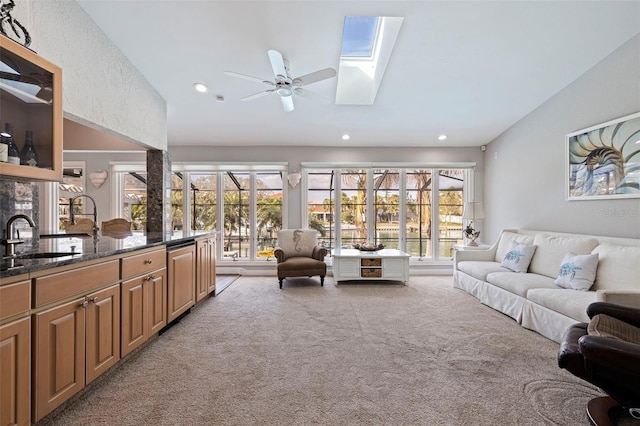 living area with recessed lighting, a skylight, a wealth of natural light, and light colored carpet