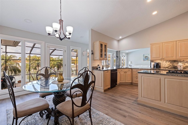 dining space with light wood-type flooring, vaulted ceiling, a notable chandelier, and recessed lighting