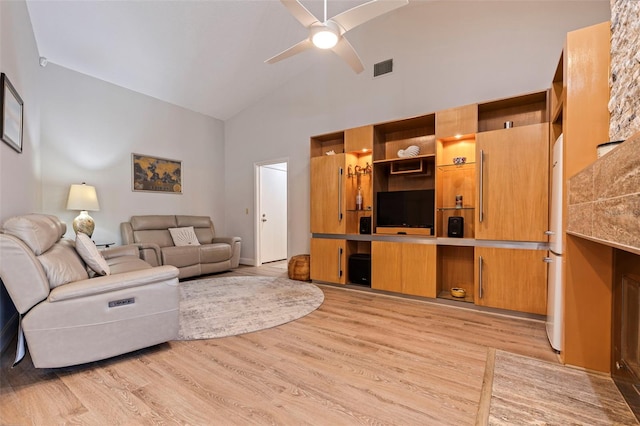 living room with high vaulted ceiling, light wood-type flooring, visible vents, and a ceiling fan