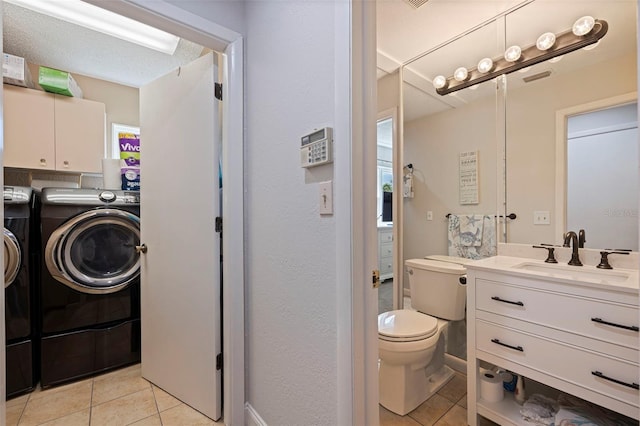 bathroom featuring toilet, vanity, washer and dryer, and tile patterned floors