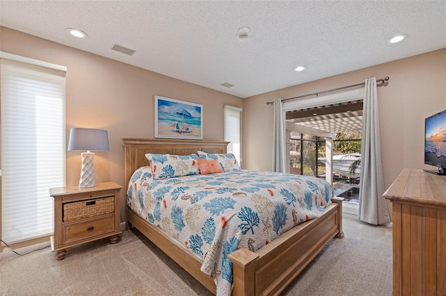 bedroom featuring access to outside, visible vents, light carpet, and a textured ceiling