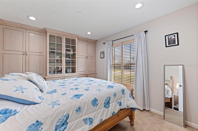 bedroom with recessed lighting, baseboards, a textured ceiling, and light colored carpet