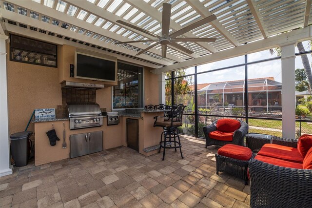 view of patio / terrace with outdoor dry bar, glass enclosure, an outdoor kitchen, and a grill