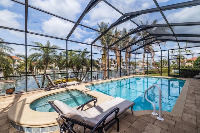 view of pool featuring a lanai, a pool with connected hot tub, and a patio