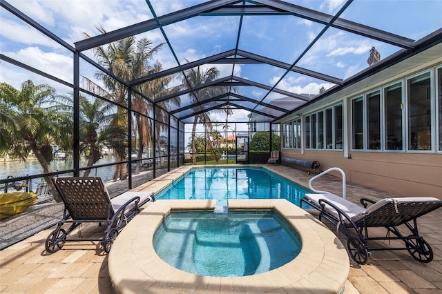 view of swimming pool featuring a patio area, a pool with connected hot tub, and glass enclosure