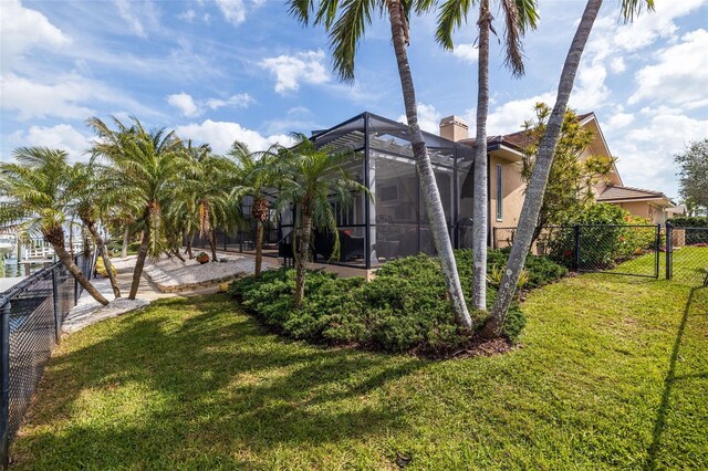 view of yard with a gate, fence, and a lanai