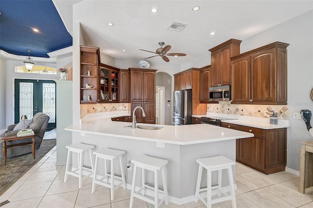 kitchen with a sink, visible vents, appliances with stainless steel finishes, and a breakfast bar area