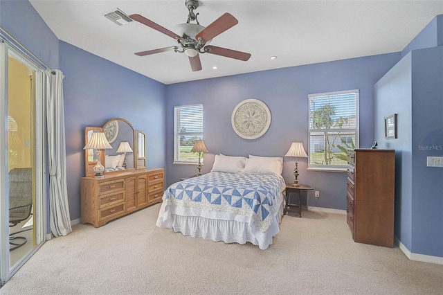 carpeted bedroom with multiple windows, baseboards, visible vents, and ceiling fan