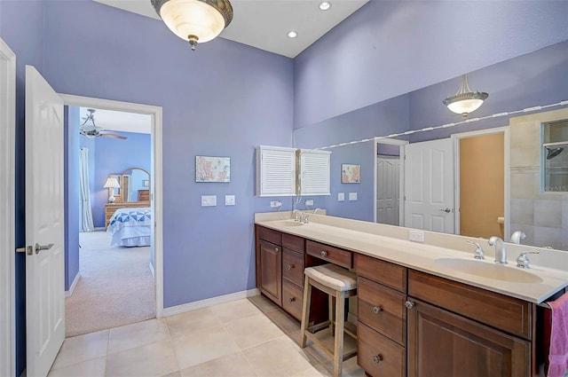 full bath featuring tile patterned flooring, baseboards, double vanity, a ceiling fan, and a sink