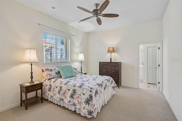 bedroom with light colored carpet, baseboards, ensuite bathroom, and ceiling fan