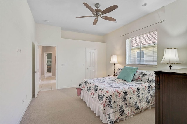 bedroom featuring light carpet, a ceiling fan, and baseboards