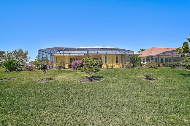 rear view of property featuring glass enclosure and a lawn