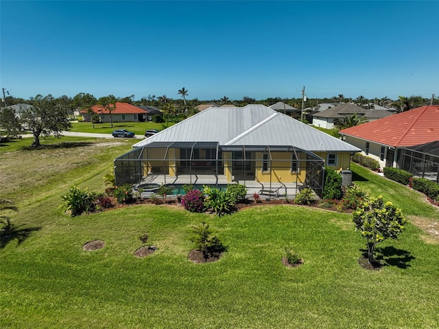 view of front of home with glass enclosure, a front lawn, an outdoor pool, and metal roof