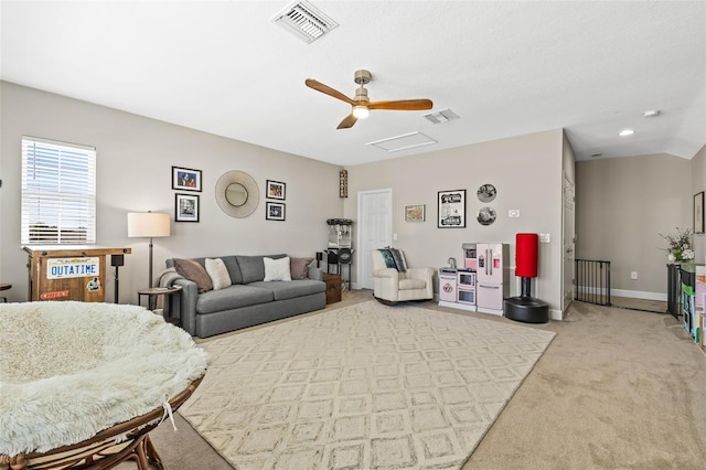 living area featuring attic access, visible vents, baseboards, and light colored carpet