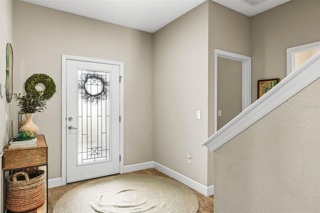 foyer with stairway and baseboards