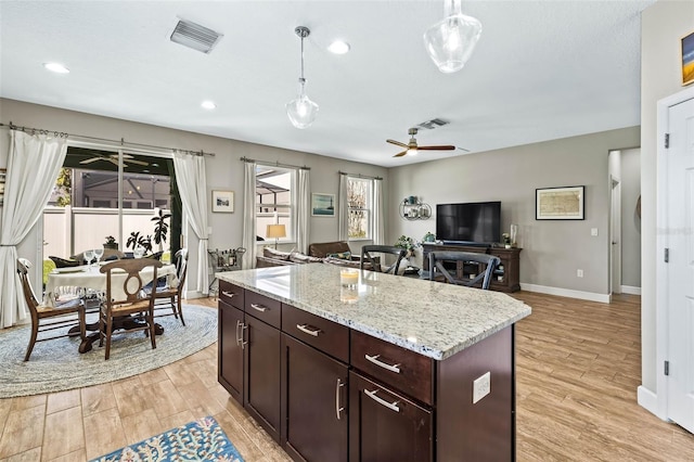 kitchen featuring a ceiling fan, light wood-type flooring, visible vents, and pendant lighting