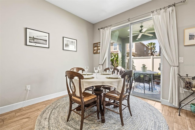 dining room with wood finished floors, a ceiling fan, and baseboards