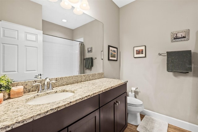 bathroom with toilet, a shower with shower curtain, wood finished floors, vanity, and baseboards