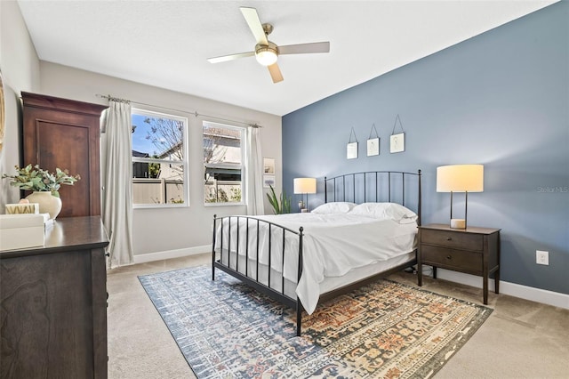 bedroom with light carpet, ceiling fan, and baseboards