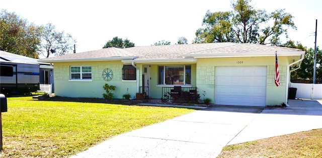 ranch-style home featuring concrete driveway, a shingled roof, an attached garage, and a front yard