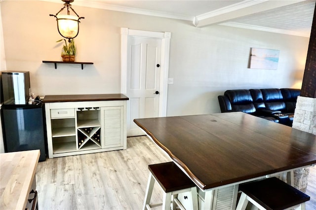 dining room with wood finished floors and crown molding