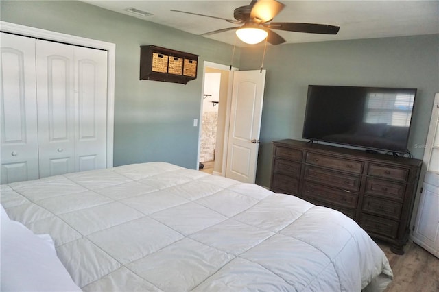 bedroom featuring visible vents, a ceiling fan, a closet, and wood finished floors