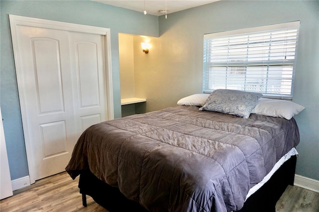 bedroom featuring a closet, baseboards, and wood finished floors