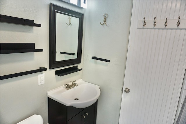 half bath featuring toilet and vanity