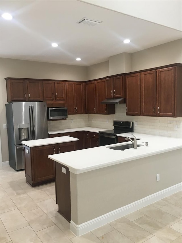 kitchen with visible vents, a peninsula, stainless steel appliances, under cabinet range hood, and a sink