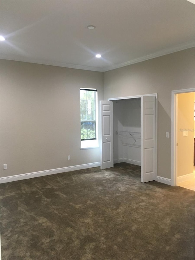 unfurnished bedroom featuring baseboards, dark carpet, crown molding, and recessed lighting