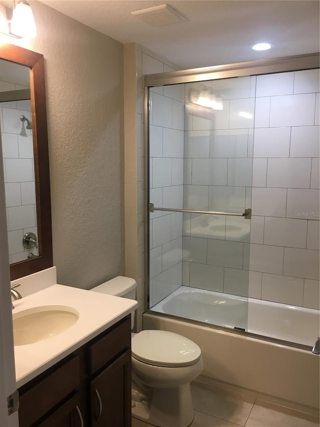 full bathroom featuring a textured wall, tile patterned flooring, toilet, vanity, and visible vents