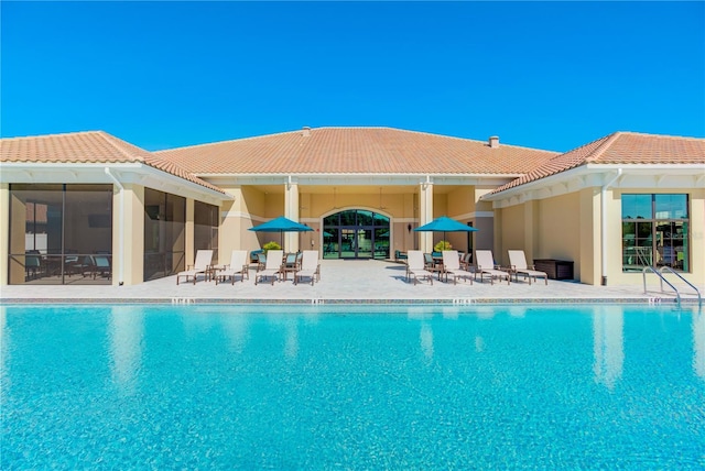 pool featuring a sunroom and a patio