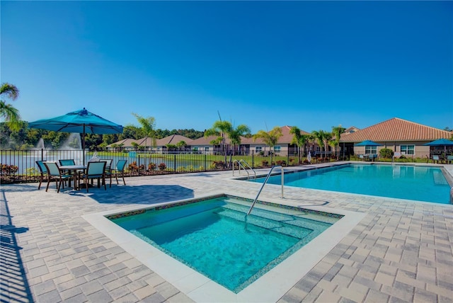 pool with a patio area and fence